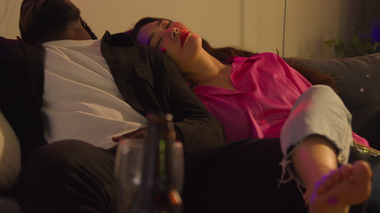 close up de una pareja acostada desmayada en el sofá después de beber alcohol en una fiesta de casa sufriendo de resaca 1