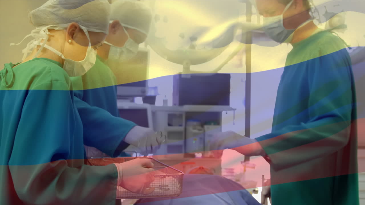 Animation of flag of camroon waving over surgeons in operating theatre