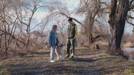 una pareja de mayores paseando a su perro en el parque