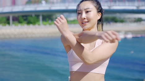 Portrait-confident-fit-woman-wearing-sportswear-runner-doing-warm-up-exercise-before-running-in-nature-represents-healthy-lifestyle