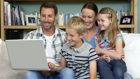 Süße-Familie-Mit-Laptop-Auf-Der-Couch-Sitzen