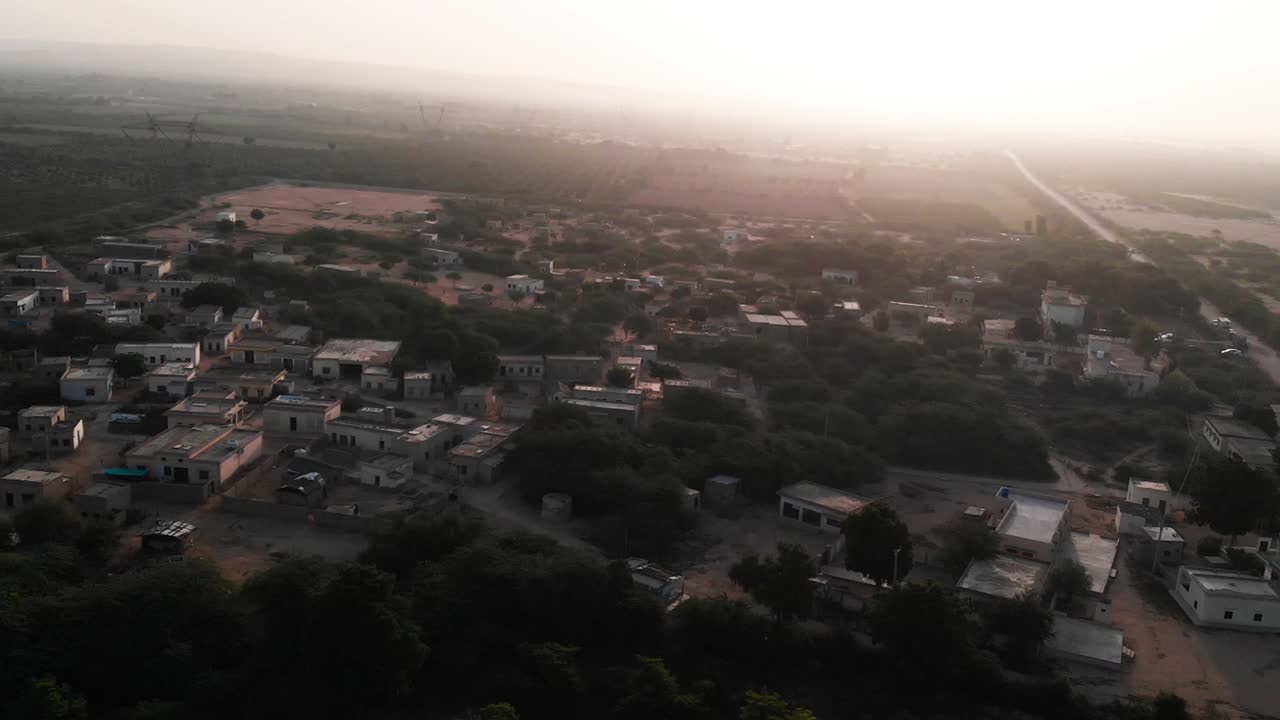 vista aérea de paralaje de la aldea rural en sindh con puesta de sol en el horizonte
