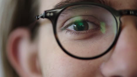 close up of young man eye opening wearing glasses looking happy healthy eyesight concept