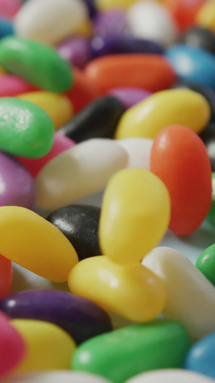 video de primer plano de dulces multicolores que caen sobre un fondo azul