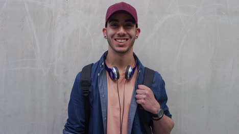 retrato atractivo joven adolescente hispano riendo feliz disfrutando de un estilo de vida exitoso estudiante de sexo masculino con aspecto confiado usando sombrero cámara lenta