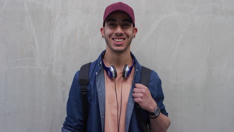 portrait attractive young hispanic teenage man laughing happy enjoying successful lifestyle male student looking confident wearing hat slow motion