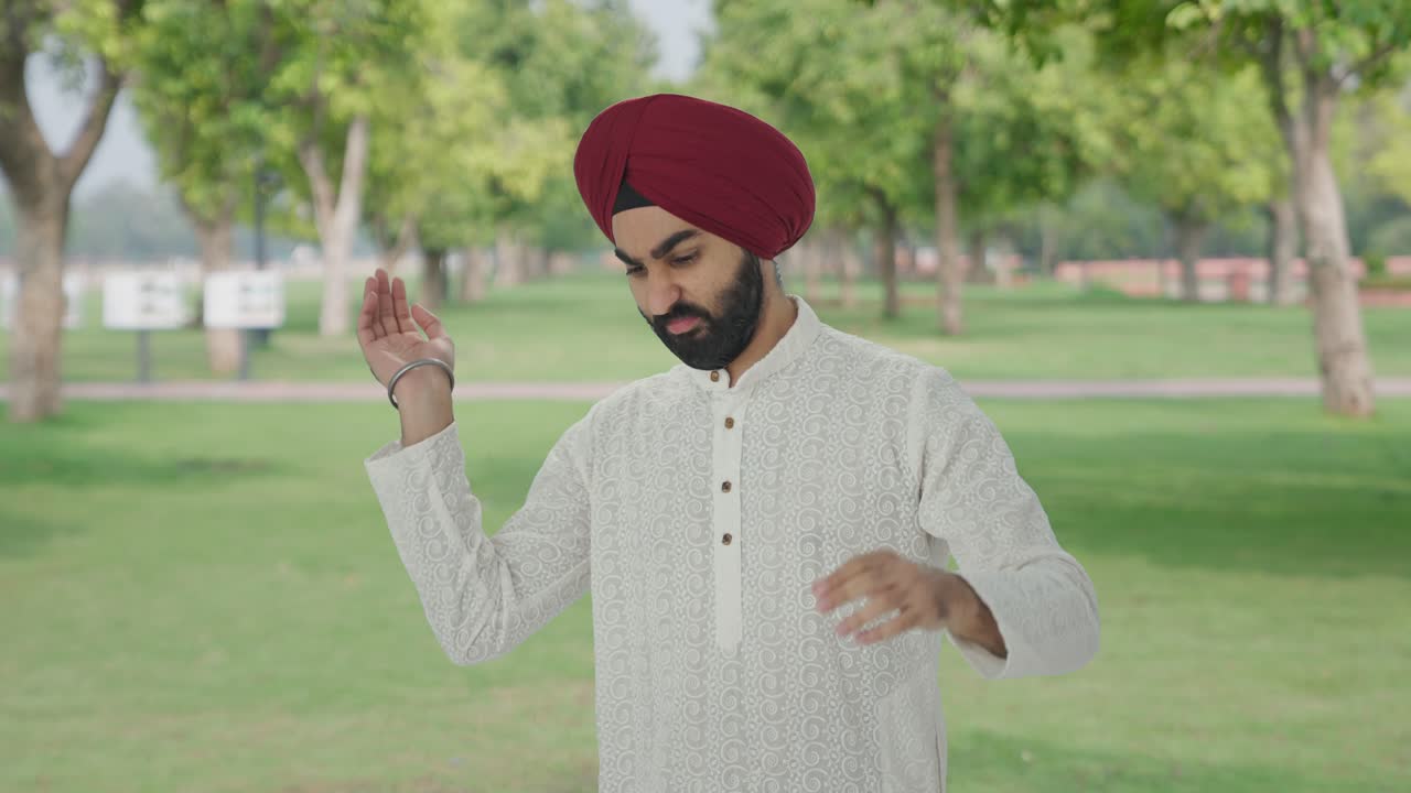 Uomo indiano Sikh frustrato che fa volare una zanzara nel parco