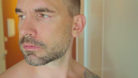 close-up portrait of a thirsty caucasian man drinking glass of water at home