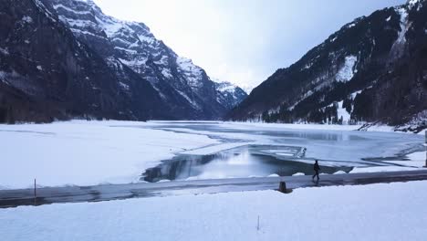 El-Dron-Sigue-A-Un-Joven-Que-Camina-Por-Un-Camino-De-Un-Lago-Artificial