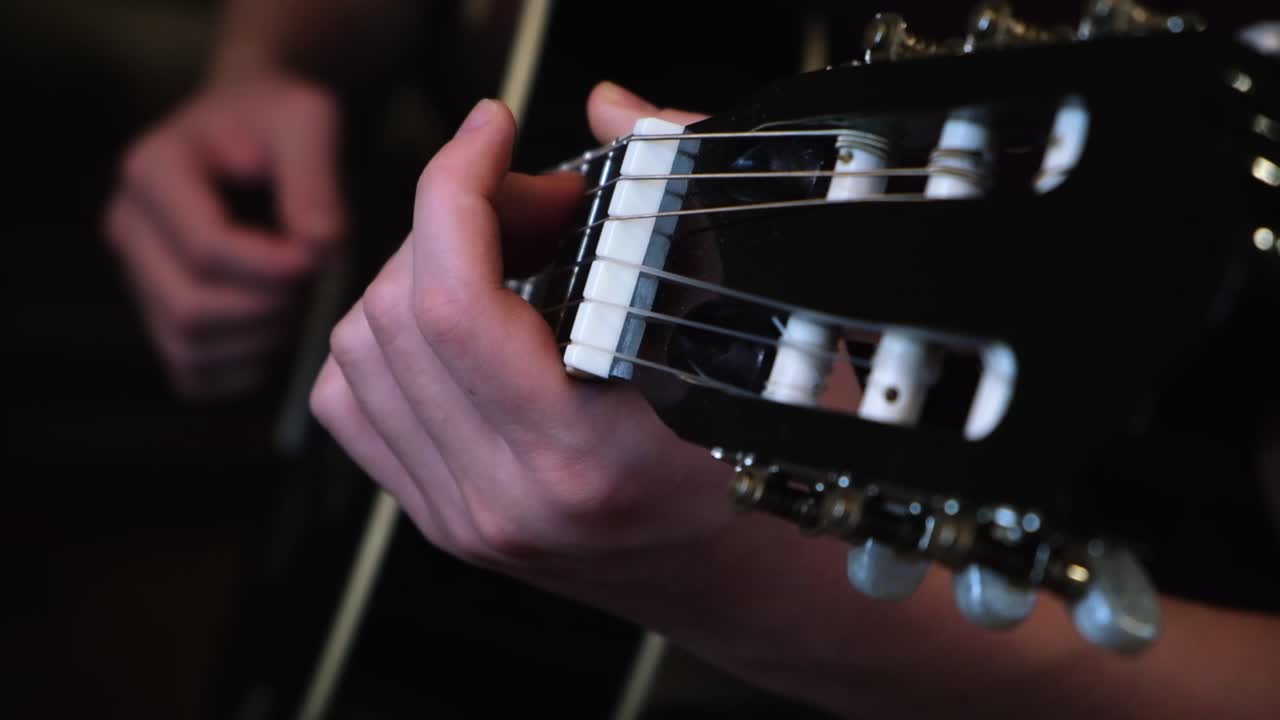 primer plano de las manos tocando la guitarra