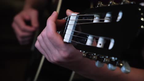 close-up of hands playing guitar