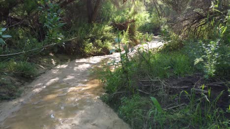 Rainwater-washes-across-a-sandy-hiking-trail-or-riverbed-in-the-wilderness-near-Alicante,-Spain---low-altitude-aerial