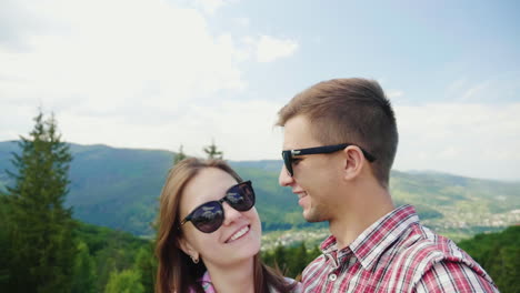 young active couple taking pictures against the backdrop of a beautiful mountain landscape