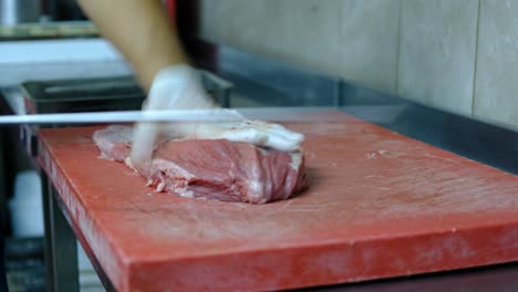 Chef-cuts-raw-meat-with-knife