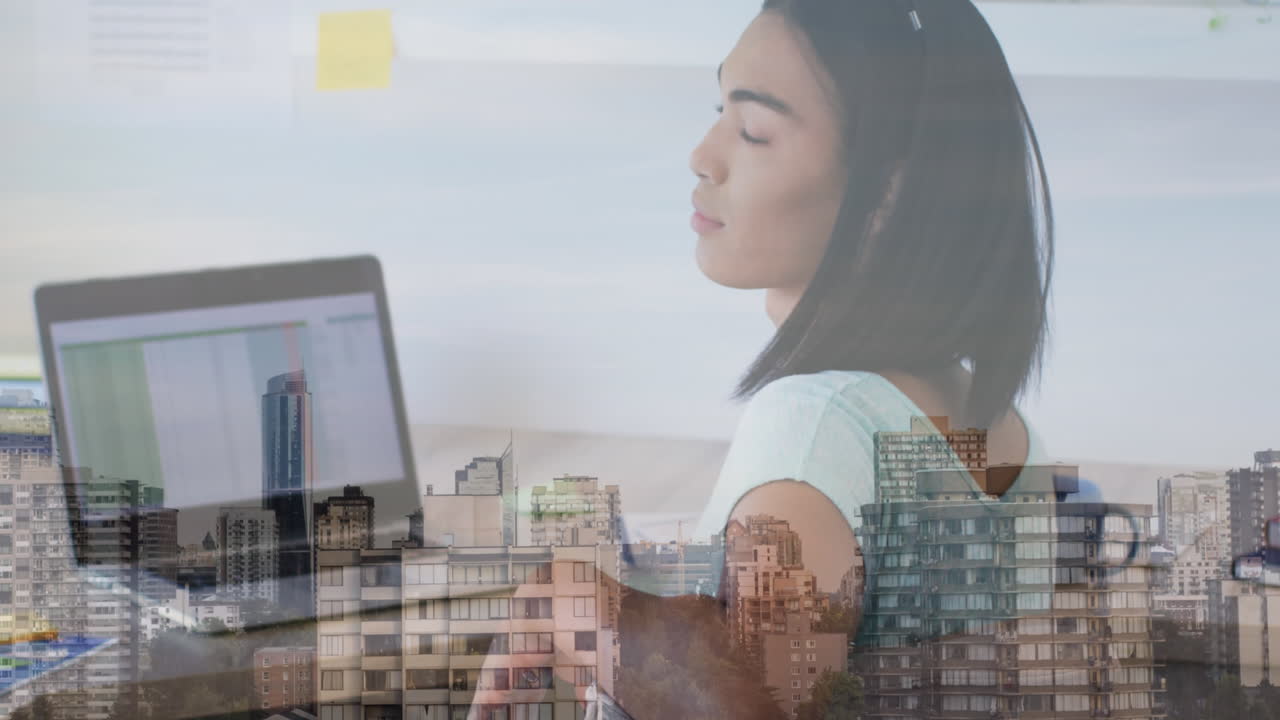 animación del paisaje urbano sobre una mujer biracial usando una computadora portátil.