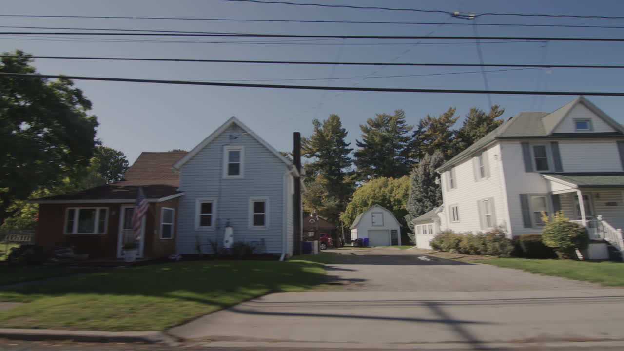 Drive along a typical street of an American town on a clear autumn day. Side view