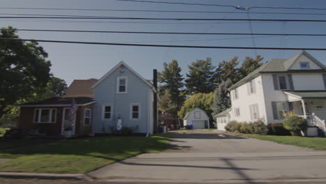 drive along a typical street of an american town on a clear autumn day. side view