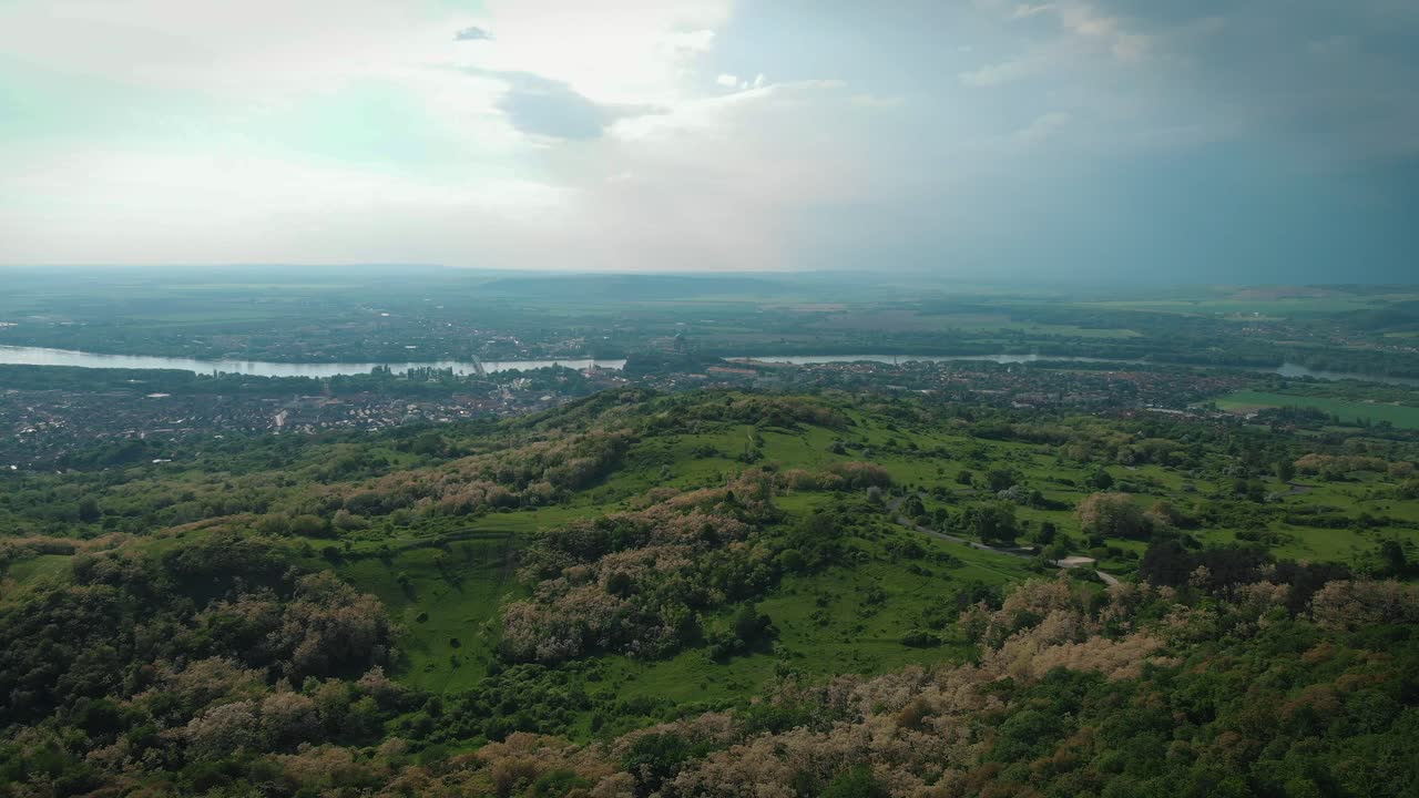 toma aérea de nubes de tormenta sobre colinas en un valle con un río