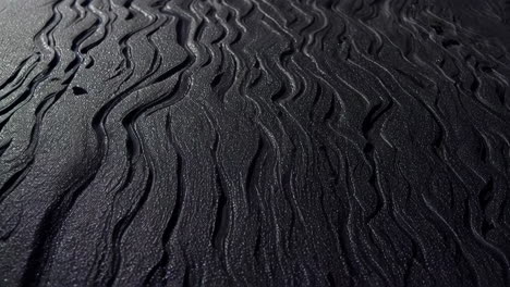 aerial view of black sand beach with wave patterns
