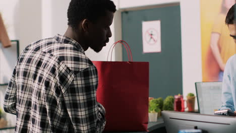 empleado dando una bolsa de papel al cliente