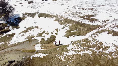 excursionistas caminando en una montaña con tiro de drones de nieve
