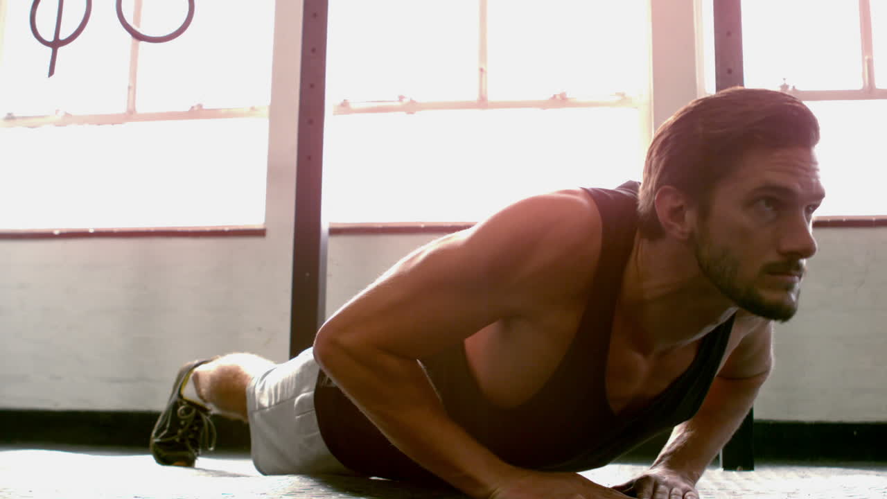 hombre en forma haciendo flexiones en el estudio de crossfit