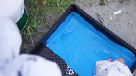person painting with blue paint