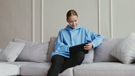 woman using tablet on a couch