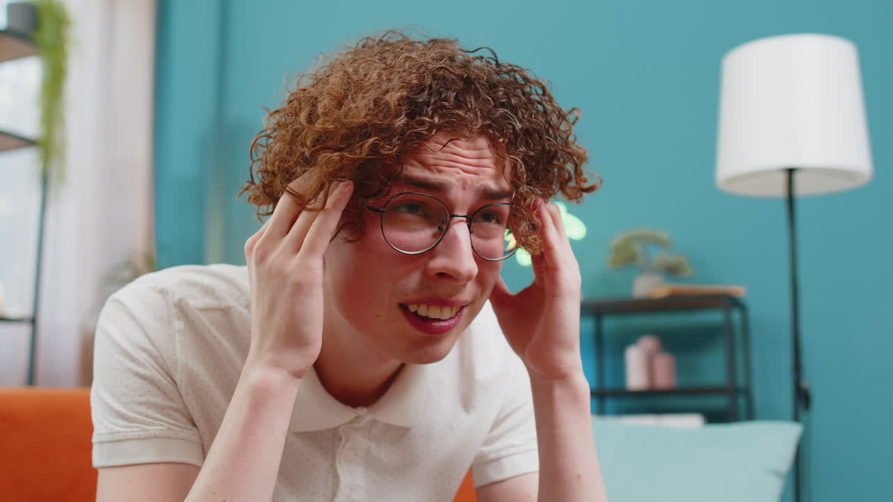 hombre descontento frotando el templo para curar el problema del dolor de cabeza sufriendo de tensión y migraña en casa