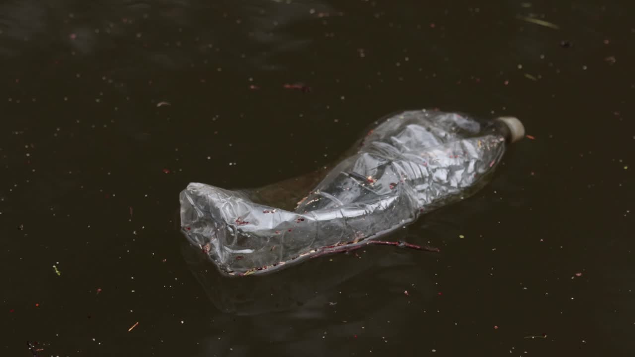 Una botella de bebida de plástico vacía flotando en un canal. Reino Unido. 2026