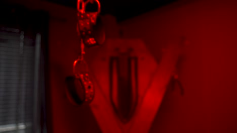 bondage and kinky handcuffs in a red room