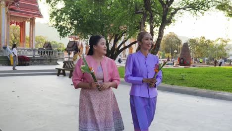 women in traditional thai clothing at a temple