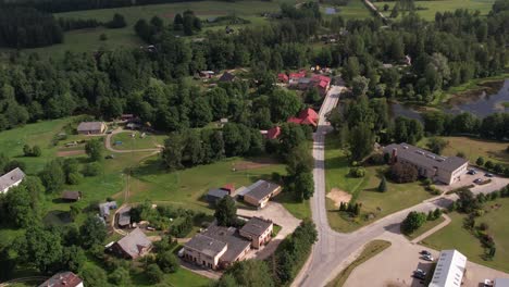 a drone view of brenguli village, capturing its quaint rural charm with scattered houses, lush green fields, and dense forests