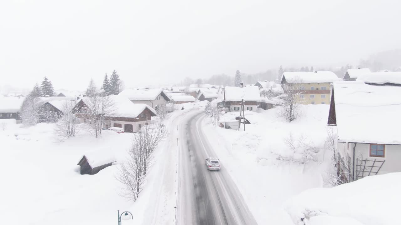 Breeze in Austrian mountains, houses covered in snow. Drone shot,.