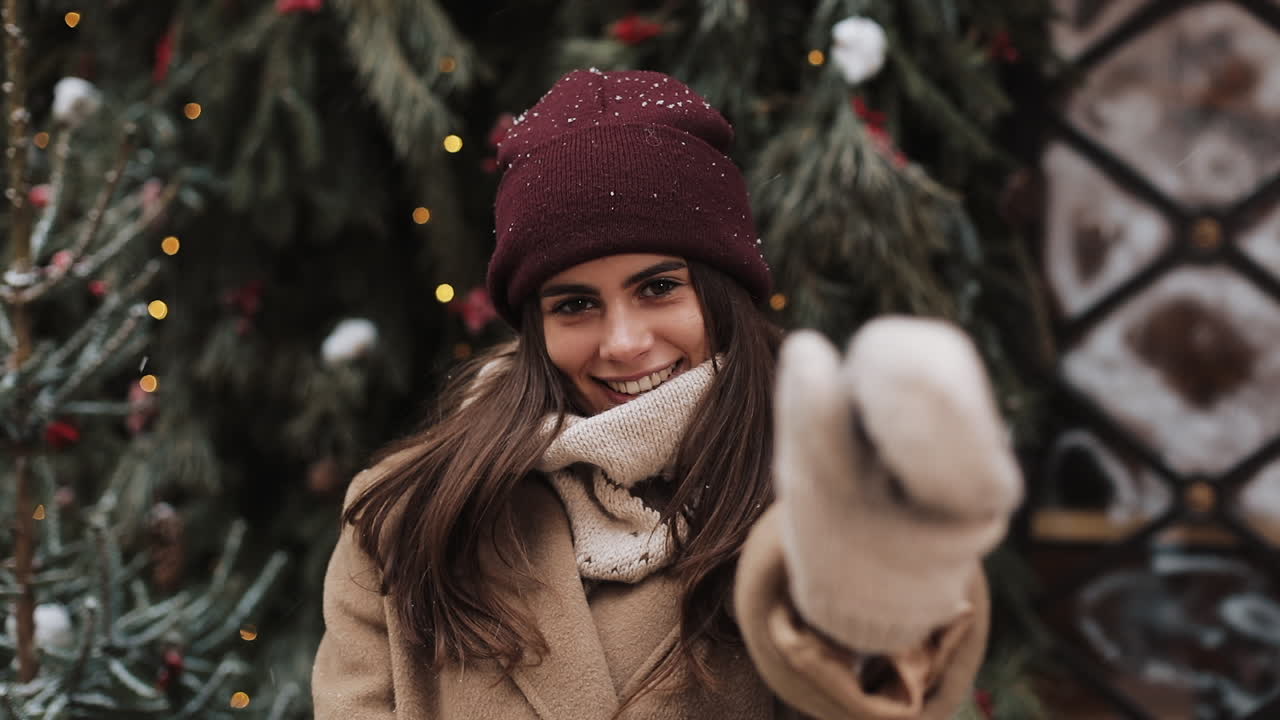 Woman in winter clothing posing in front of Christmas tree