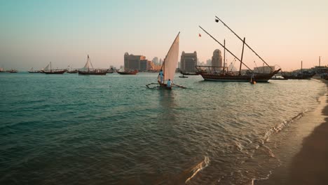 traditional arabic fishermen with dhows with qatar flag in arabic gulf