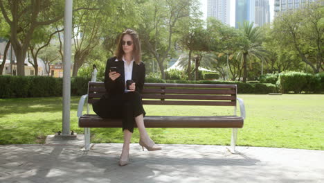 mujer sentada en el banco de un parque