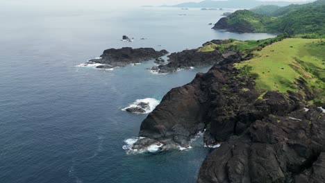 aerial view of stunning coastal, island rocks and lush hills facing turquoise ocean waters