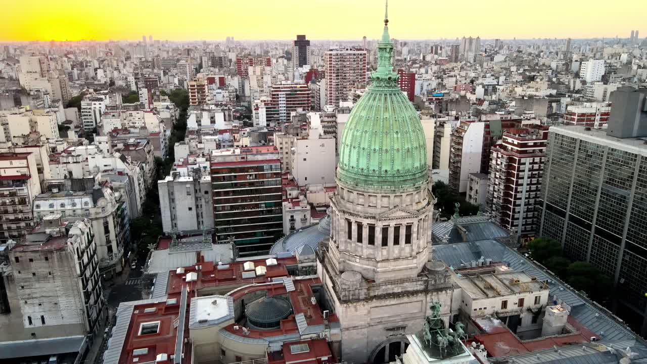 impresionante toma aérea que captura la cúpula del palacio del congreso nacional argentino y la heroica estatua de quadriga contra el paisaje urbano del centro y la hermosa puesta de sol naranja en el fondo