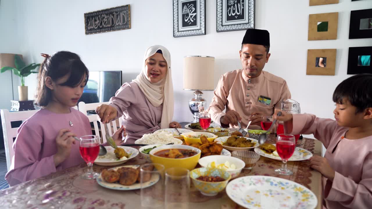 hari raya aidilfitri - familia musulmana que come en casa el día de eid al-fitr