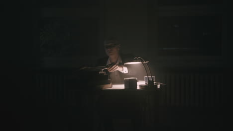 pale bald accountant looks through the tax papers in the weird room at night
