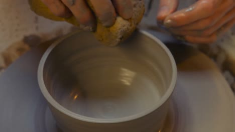 potter making a earthen pot on a pottery wheel