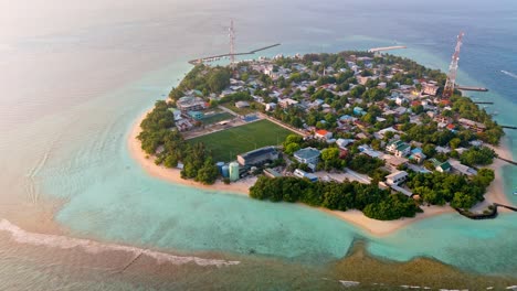 a breathtaking aerial drone view captures rasdhoo island bathed in the warm glow of sunset in the maldives.