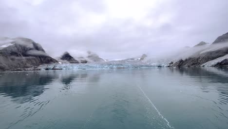 Schwenk-Einer-Gletscherlandschaft,-Die-Sich-Im-Arktischen-Meer-Spiegelt,-Während-Einer-Expeditionsbootfahrt-An-Der-Nordküste-Von-Spitzbergen-An-Einem-Bewölkten-Tag