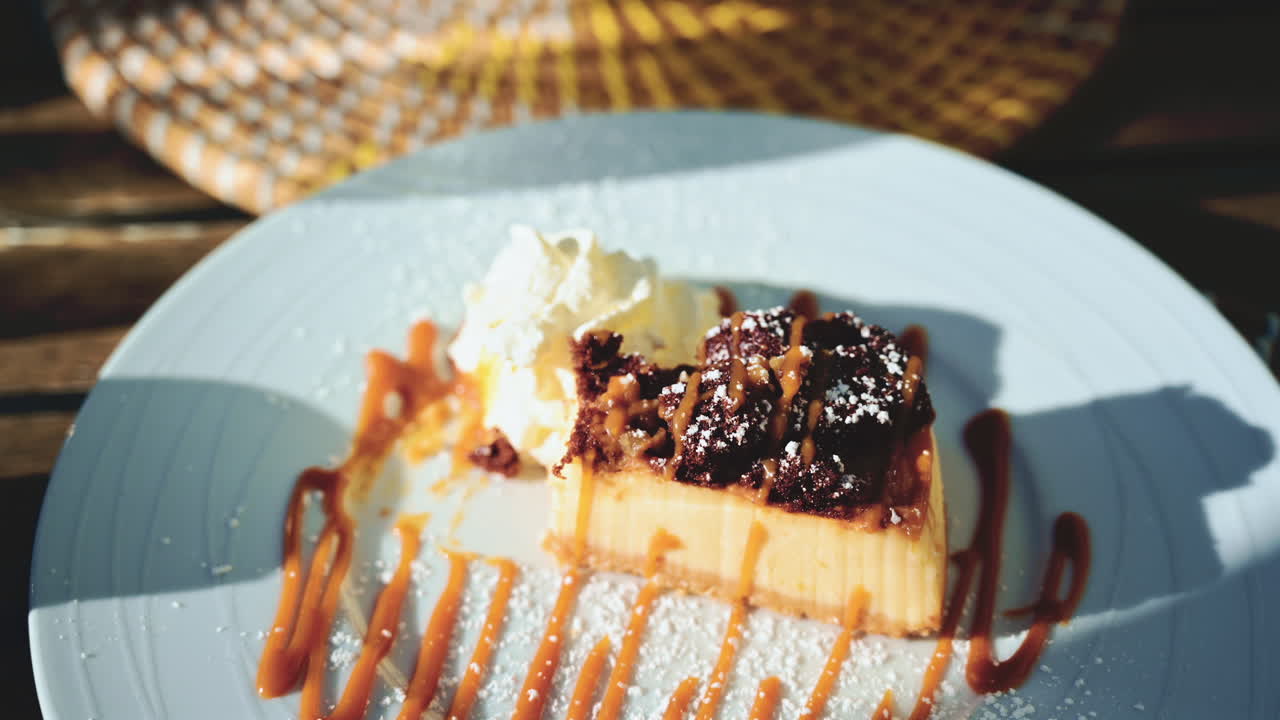 Close up of a spoon taking a bite from a caramel dessert with brownie topping
