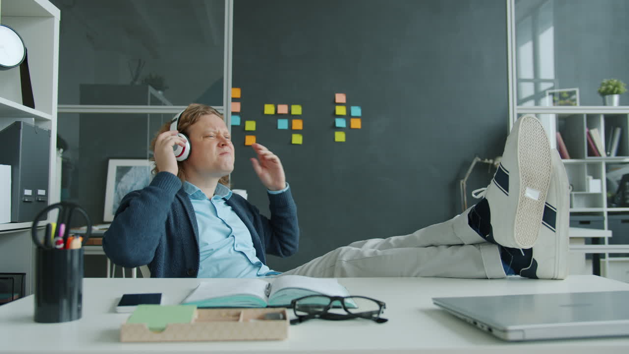 Man Relaxing at Work, Listening to Music