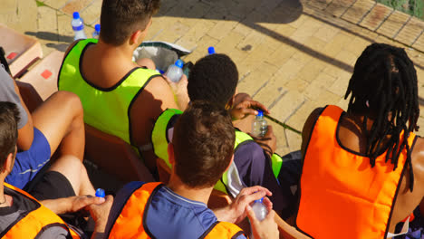 jugadores de fútbol sentados en el estadio en un día soleado 4k