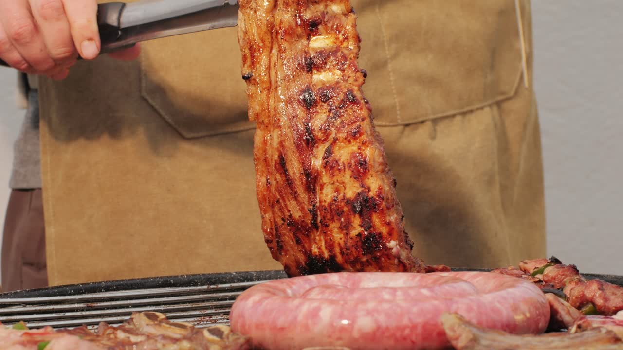 Traditional spanish barbeque, big sausage chorizo botifarra, pork and beef ribs on grill with fire, american style cooking, chef grilling meat fat food, steaks and sausages on bbq. High quality 4k footage