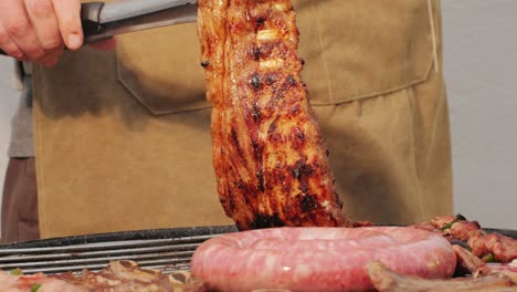 traditional spanish barbeque, big sausage chorizo botifarra, pork and beef ribs on grill with fire, american style cooking, chef grilling meat fat food, steaks and sausages on bbq. high quality 4k footage