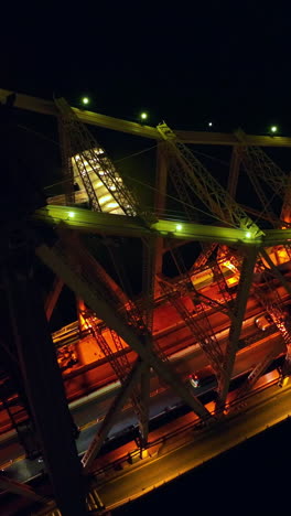 bridge in new york beautifully highlighted at night. multiple cars moving by the bridge. top view at the black backdrop. vertical video